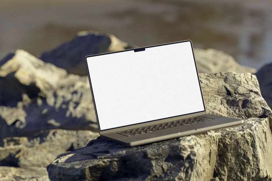 Une installation photo élégante avec un ordinateur portable en train de retoucher un portrait et un appareil photo entouré de cartes SD sur une surface en béton.